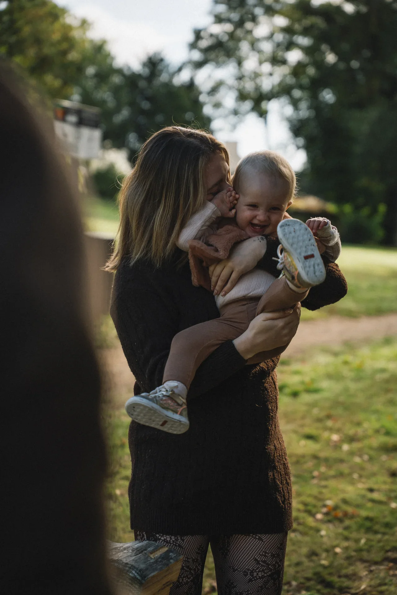 Une mère et son bébé partagent un rire en plein air