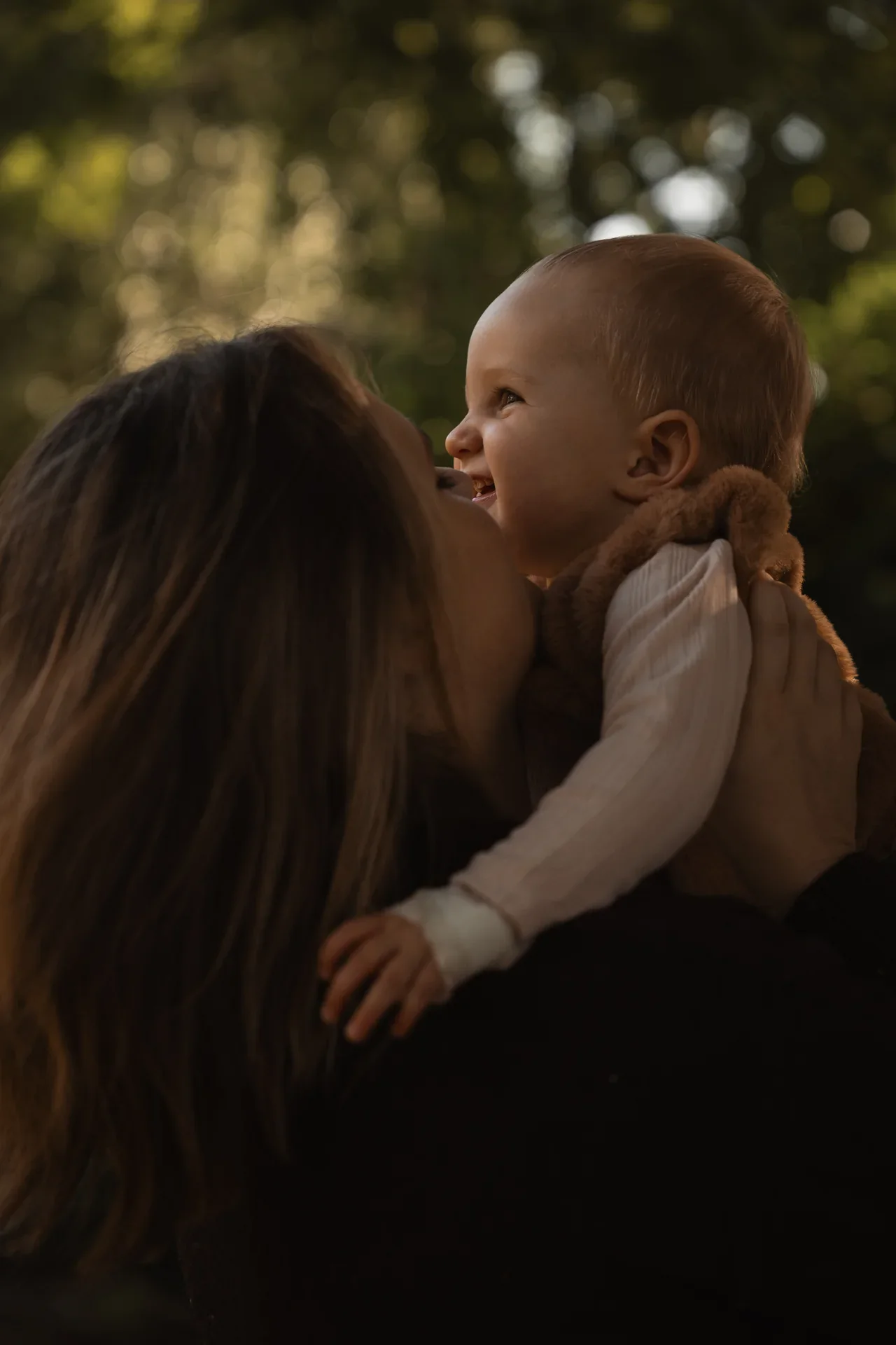 Une mère embrasse son bébé dans les bois